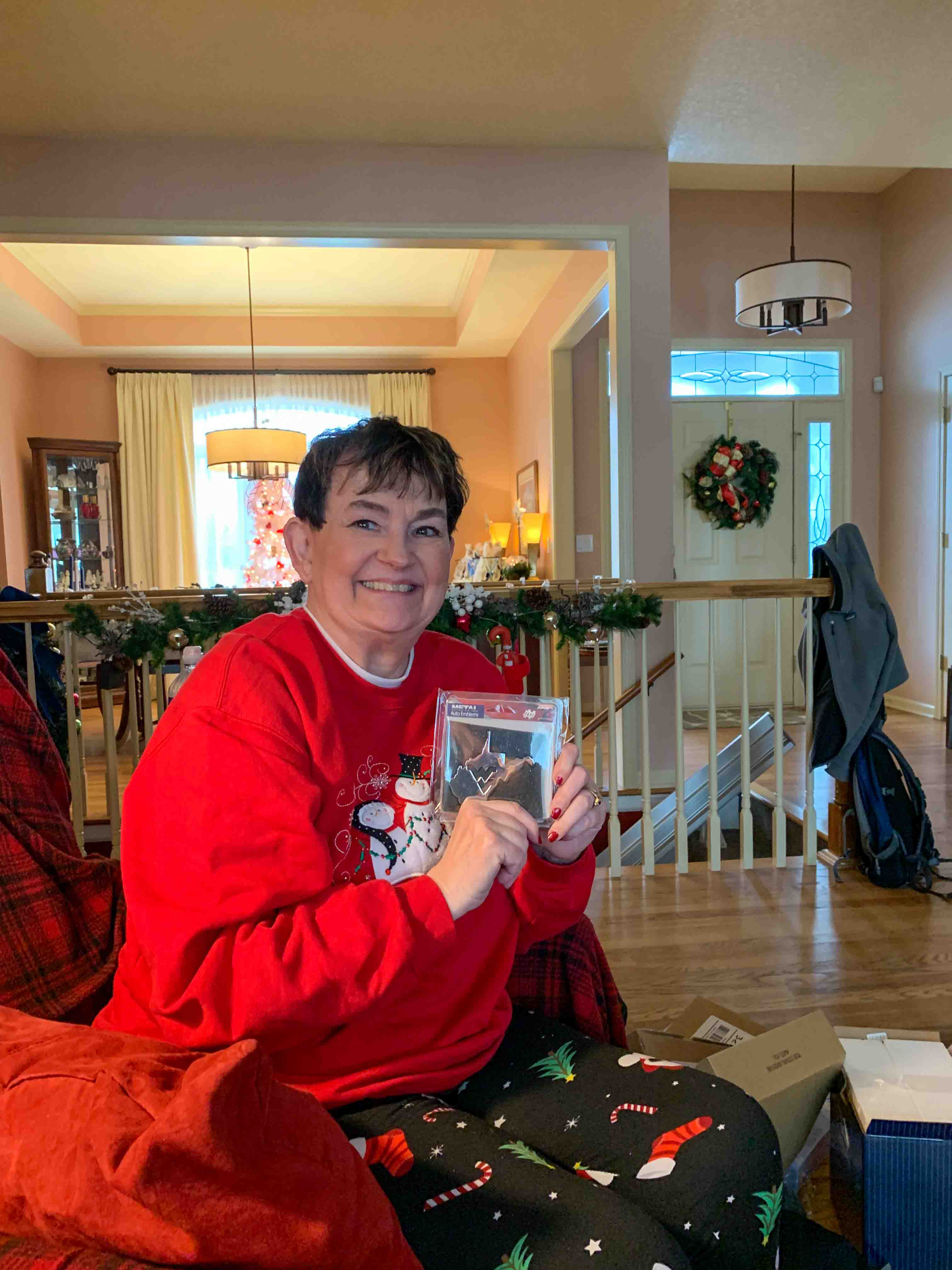 Opening gifts - this one is a special WVU decal for her car - thanks Brian!                                        Location:  11207 Wilmar Dr, Liberty MO 64068                                 Source: Julane Crabtree                                Date:  25 Dec 2022